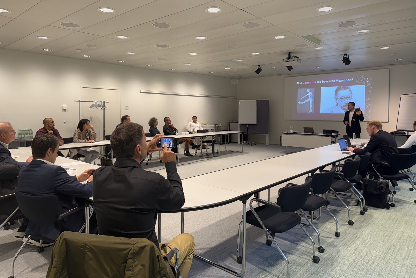 Un partecipante fotografa una slide con lo smartphone in una sala del workshop gremita