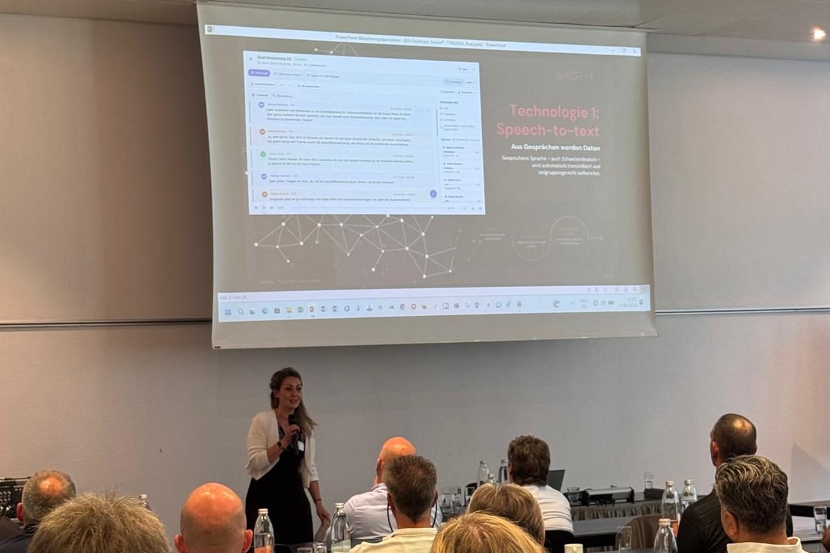 Relatrice con microfono che presenta una trascrizione dal vivo con il titolo speech-to-text