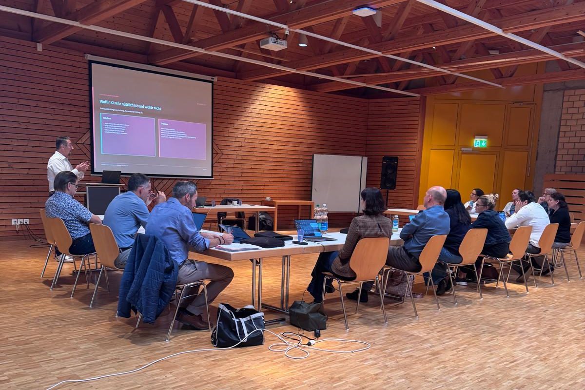 Workshop IA alla Schule Entfelden con partecipanti ai tavoli e una slide sui punti di forza e i limiti dell'IA
